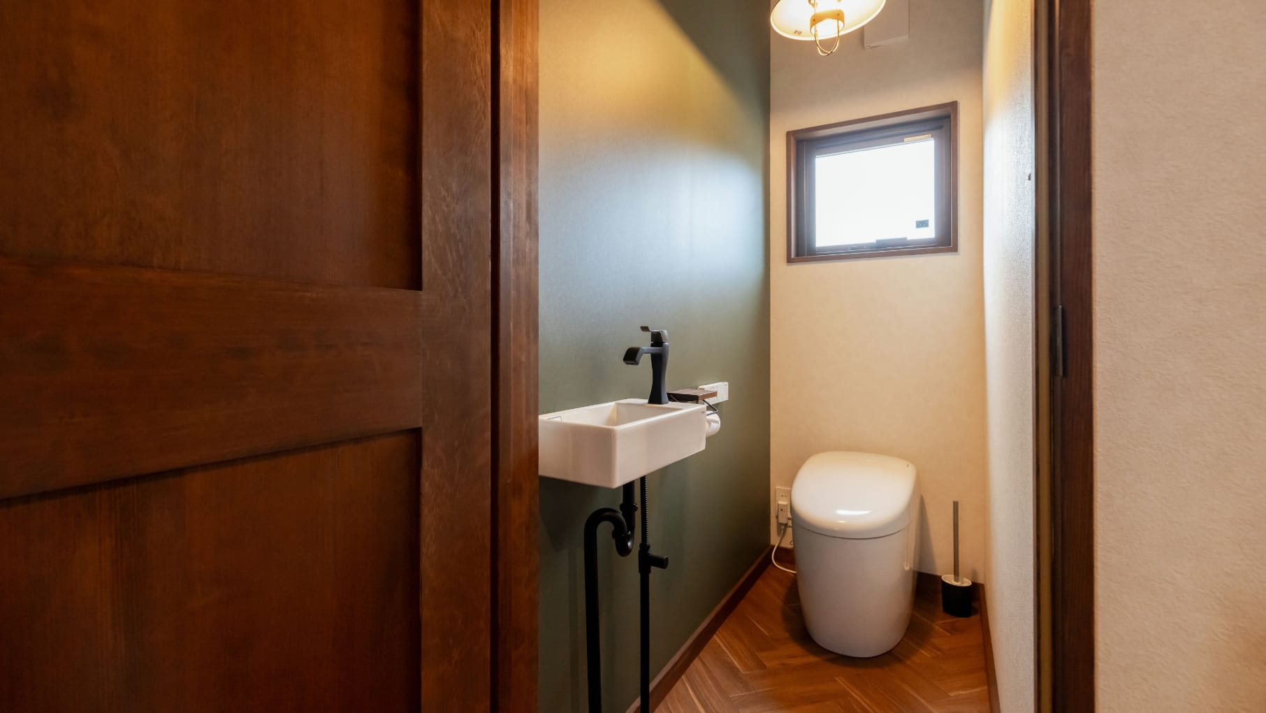 モスグリーンのアクセントクロスがお洒落なトイレ